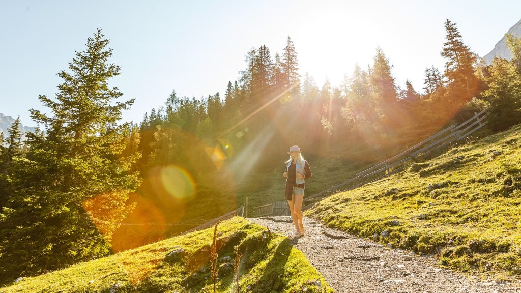 Woman hiking on a sunny mountain trail near St. Martin am Tennengebirge in summer
