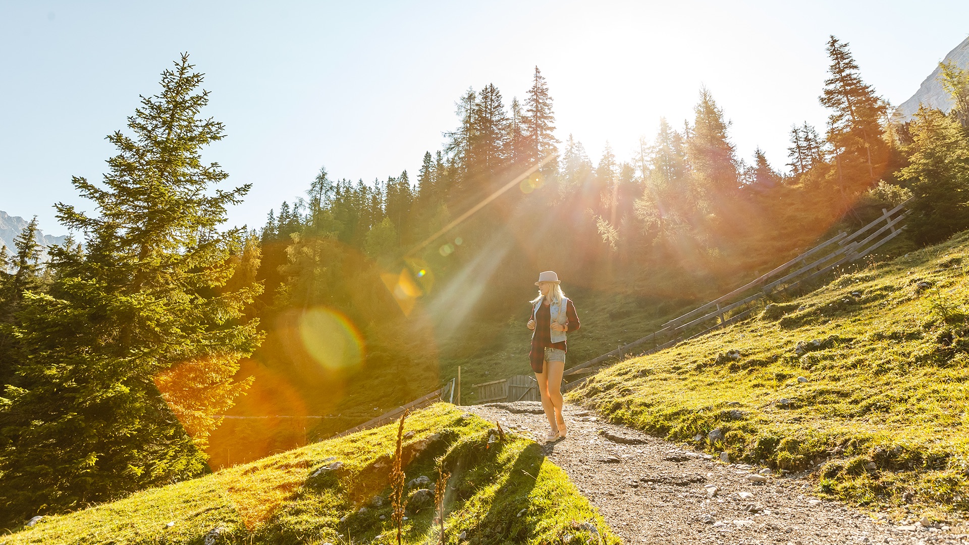 Woman hiking on a sunny mountain trail near St. Martin am Tennengebirge in summer