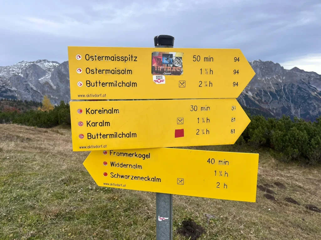 Gele wandelwegwijzers met bergen op de achtergrond