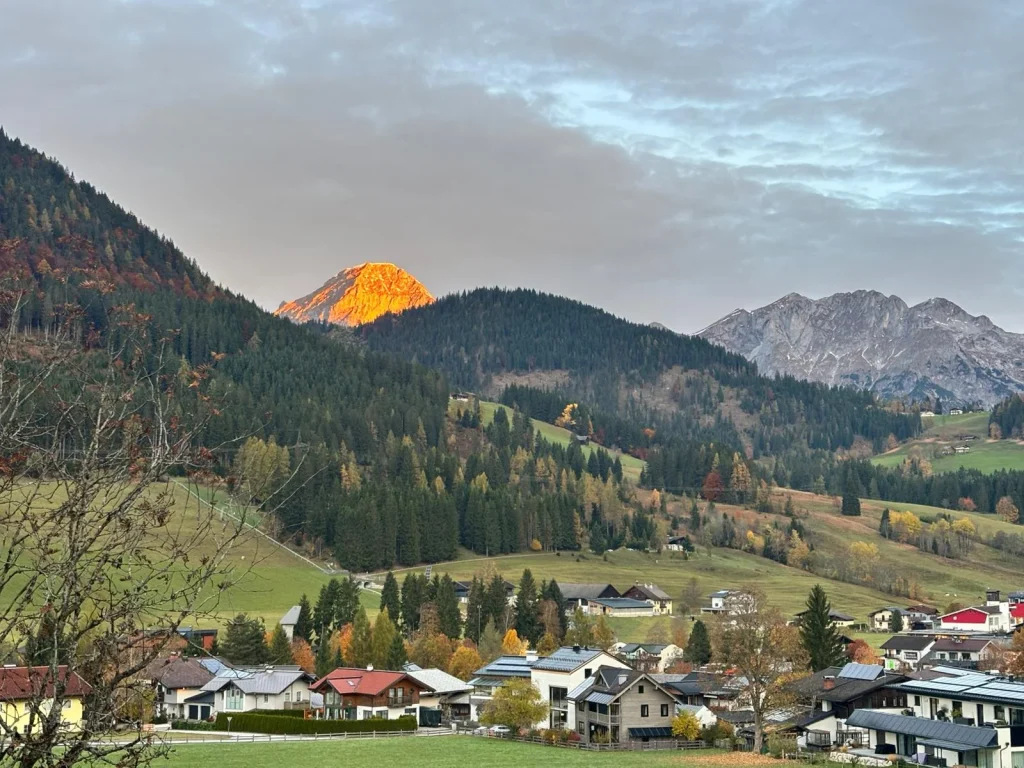 Het dorp en een oplichtende bergtop, gezien vanaf het balkon aan de voorkant van het hotel