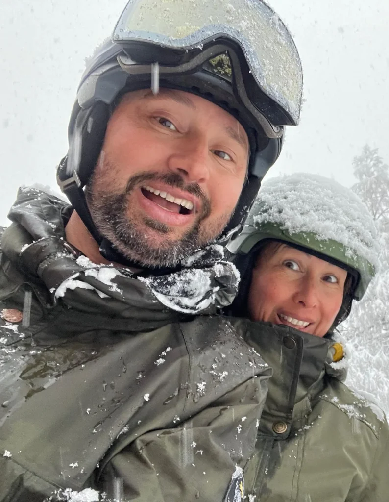 Auke and Chantal, hosts of Hotel Alpenhof, smiling in ski helmets on a snowy day